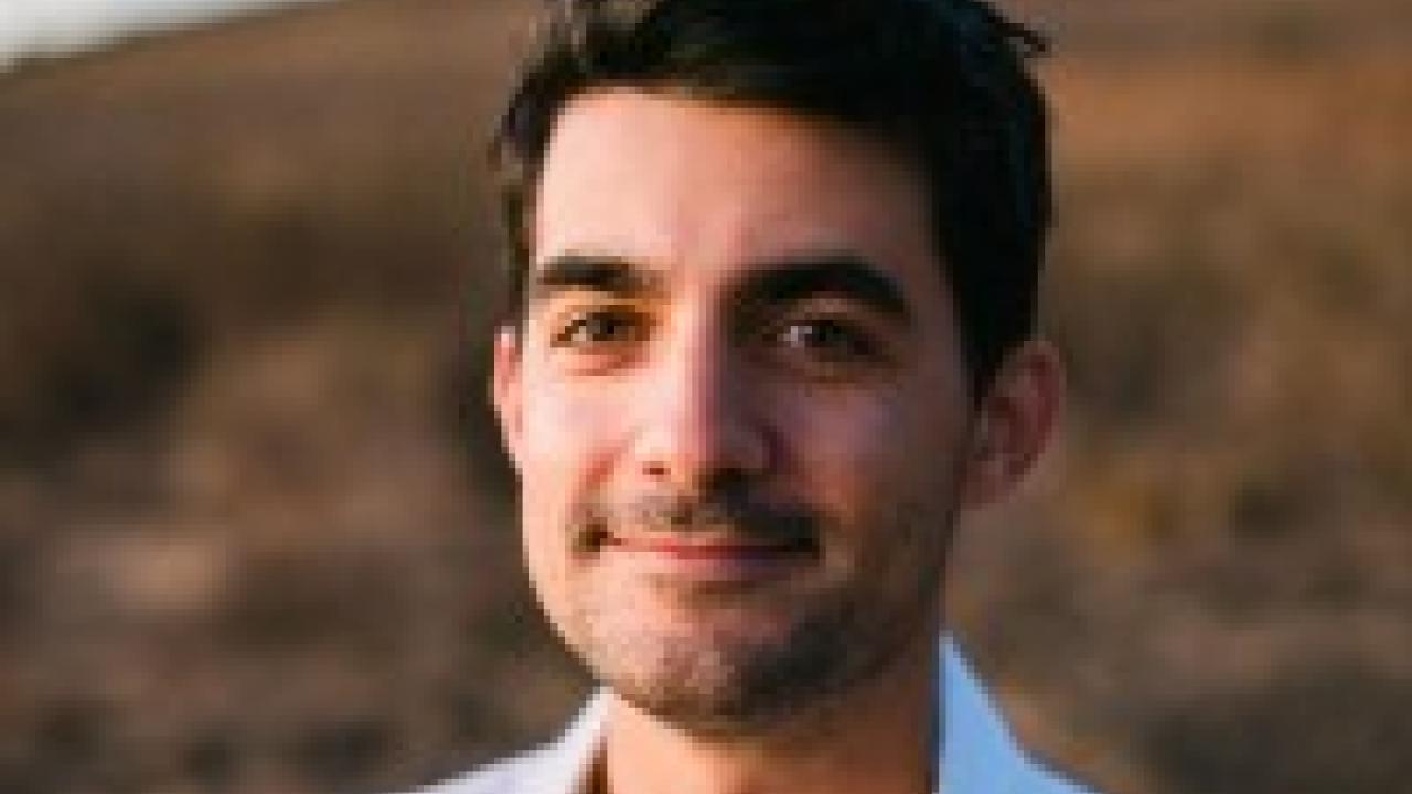 Young man portrait outdoors at golden hour, white shirt and gentle smile